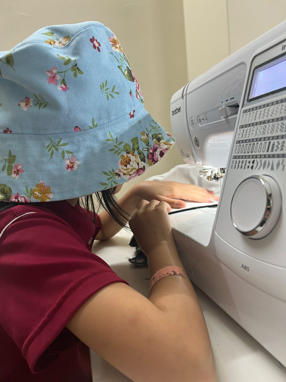 A young student learning to sew at Two Moles